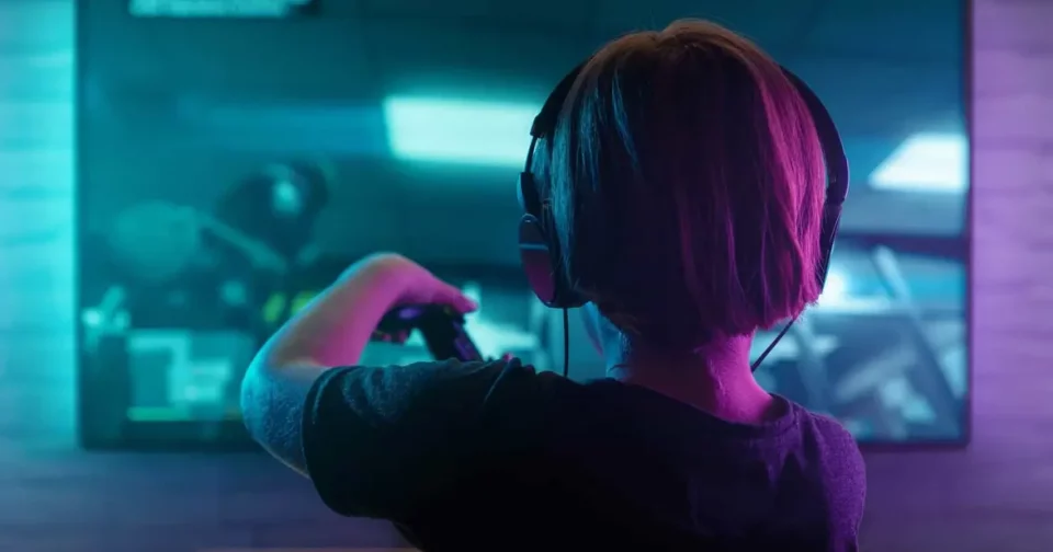 Criança Jogando Playstation 4 Em Uma Sala Escura. Imagem: Rangizzz/Shutterstock
