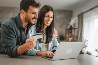 Casal Fazendo Compras Online Com Cartão De Crédito - Imagem: Miljan Zivkovic/Shutterstock