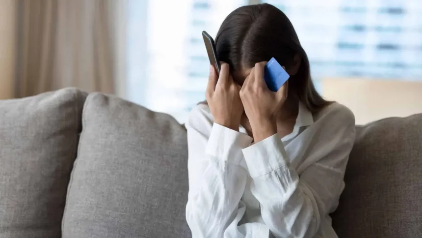 Mulher Desesperada Ao Telefone Ao Sofrer Um Golpe / Crédito: Fizkes(Shutterstock / Divulgação)